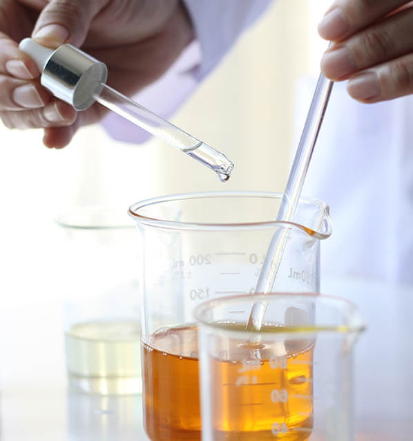 Scientist mixing oils in lab