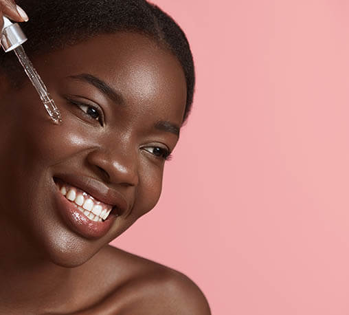 Woman applying beauty oil to face